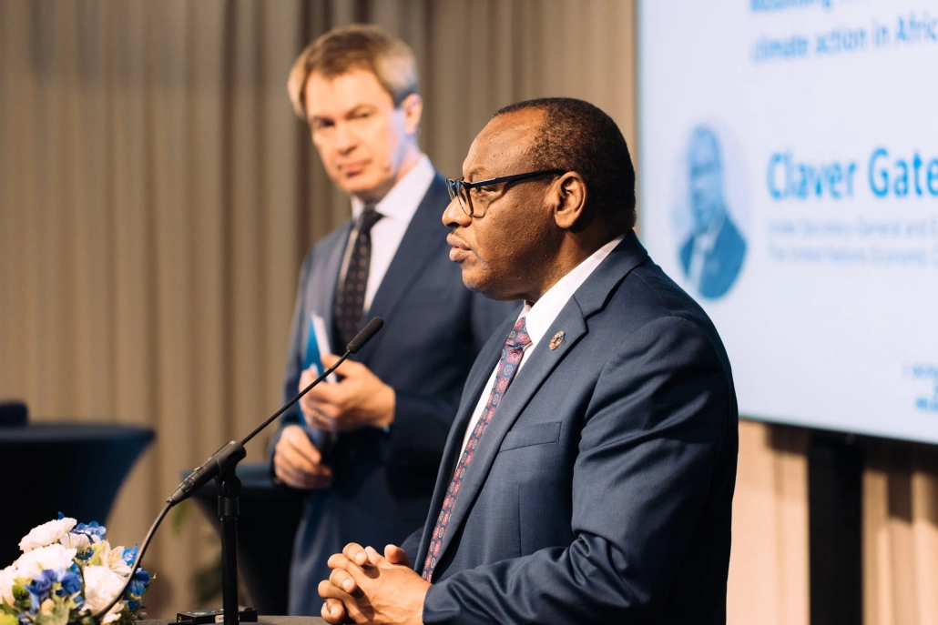 Two men stand on a stage. One is the UN's Claver Gatete.